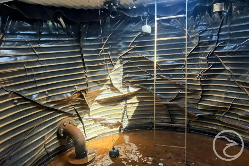 water tank liner deterioration visible inside an industrial storage tank